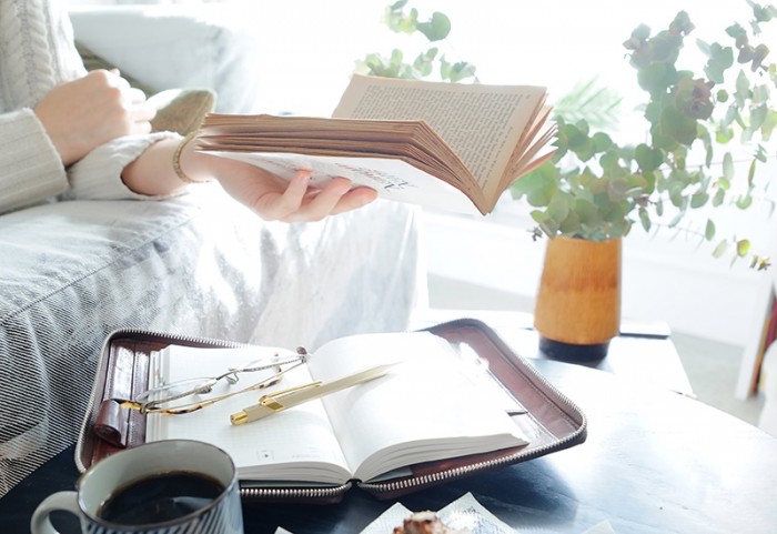 リノベーションされてリビングで本を読む女性