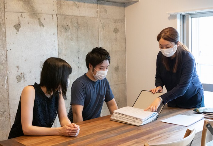テーブルに座るご夫婦に説明する設計担当