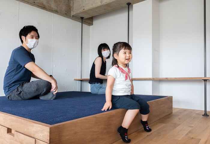 小上がりに座る少女と夫婦