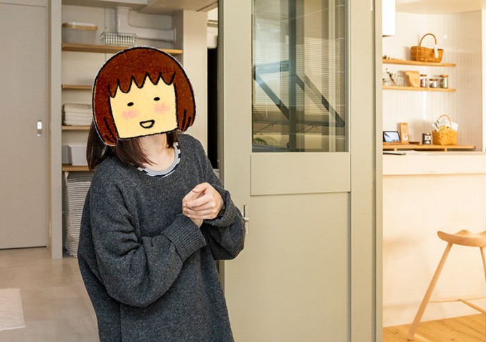 洗面室とキッチンの間にあるドアの前に立つたかはしさん
