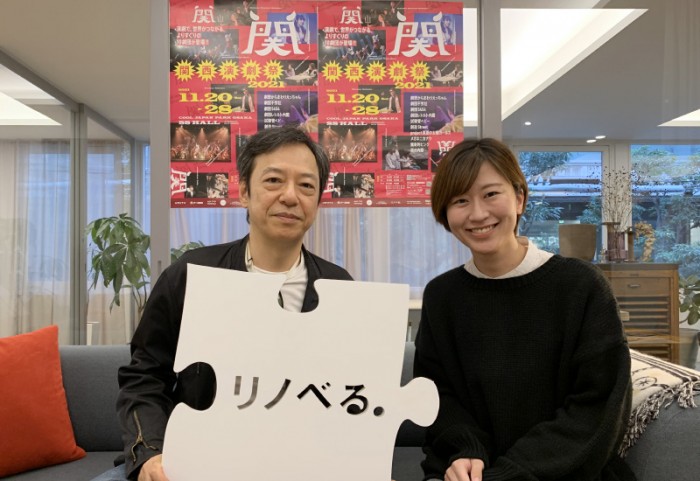 ショールーム内でリノベるロゴプレートを持つ板尾さんとリノベるスタッフ