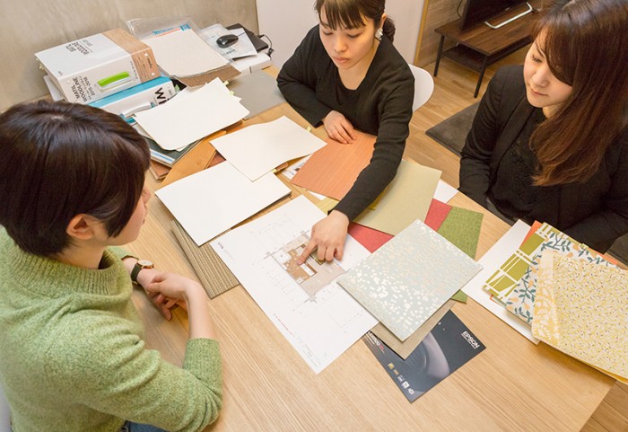 テーブルの上の図面を見るHさん、宇田川、細井