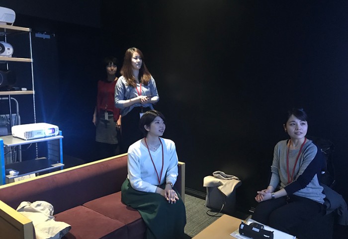 エプソン販売さんのショールームでプロジェクターの試聴をするHさん、宇田川、細井