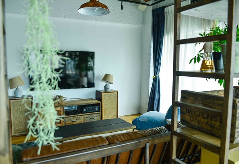 リノベーションされた部屋のリビングにあるソファ、ローテーブル、テレビ台